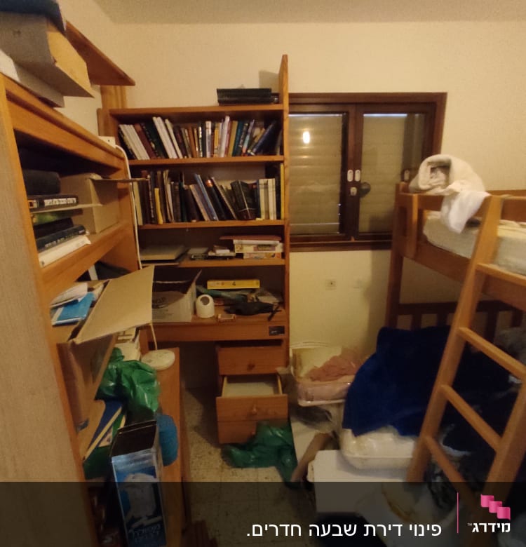 חדר עם מדפים עמוסים בספרים ופריטים שונים